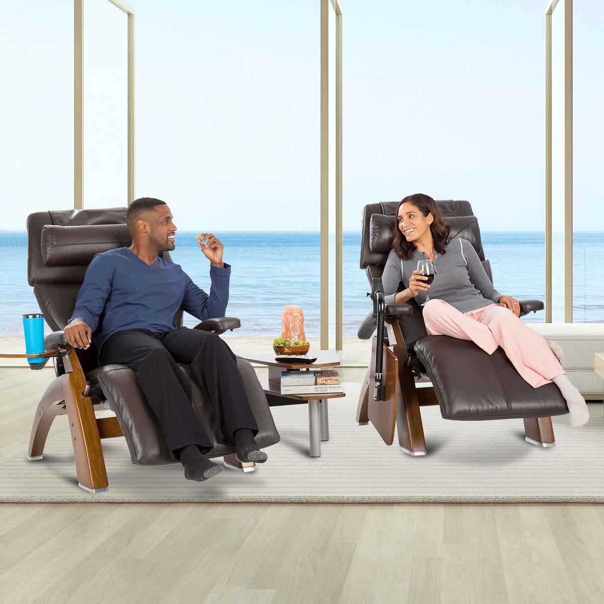 Perfect Chair Accessory Table shown between two recliners by oceanfront window, holding drinks and snacks for relaxing couple