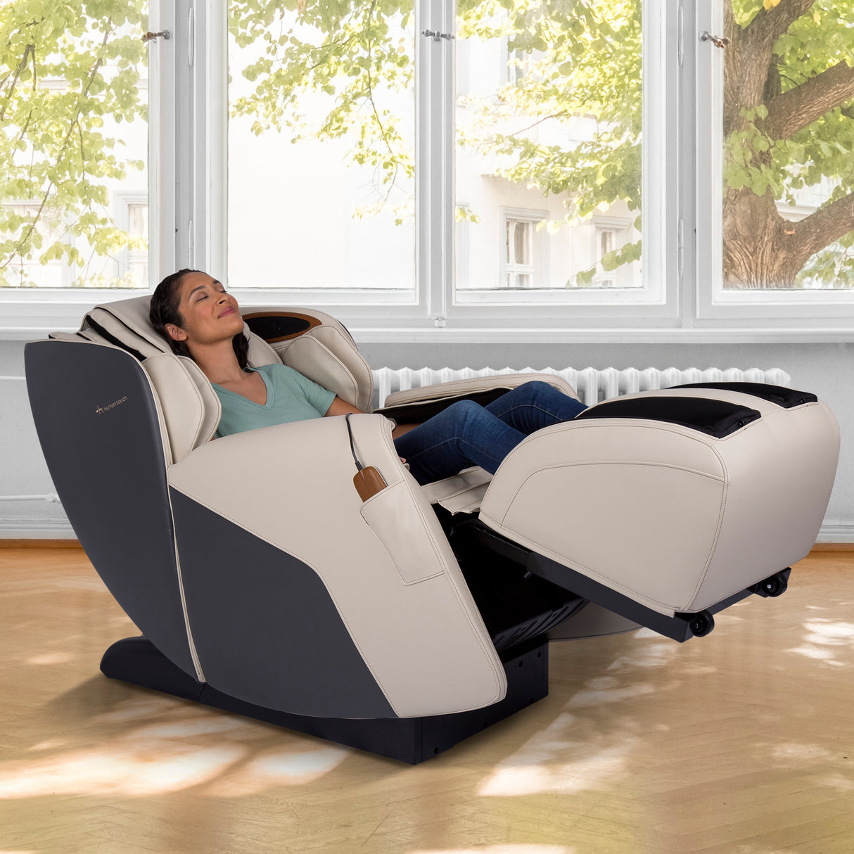 Woman relaxing in the Human Touch Quies Massage Chair with extended footrest and reclined position in bright room