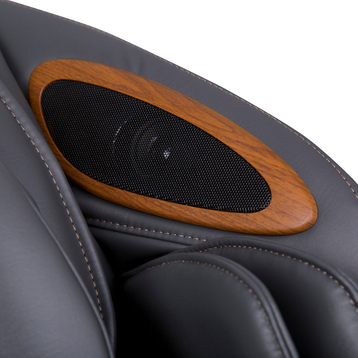 Close-up of black leather and wood detail on the Human Touch Quies Massage Chair armrest with speaker grille.