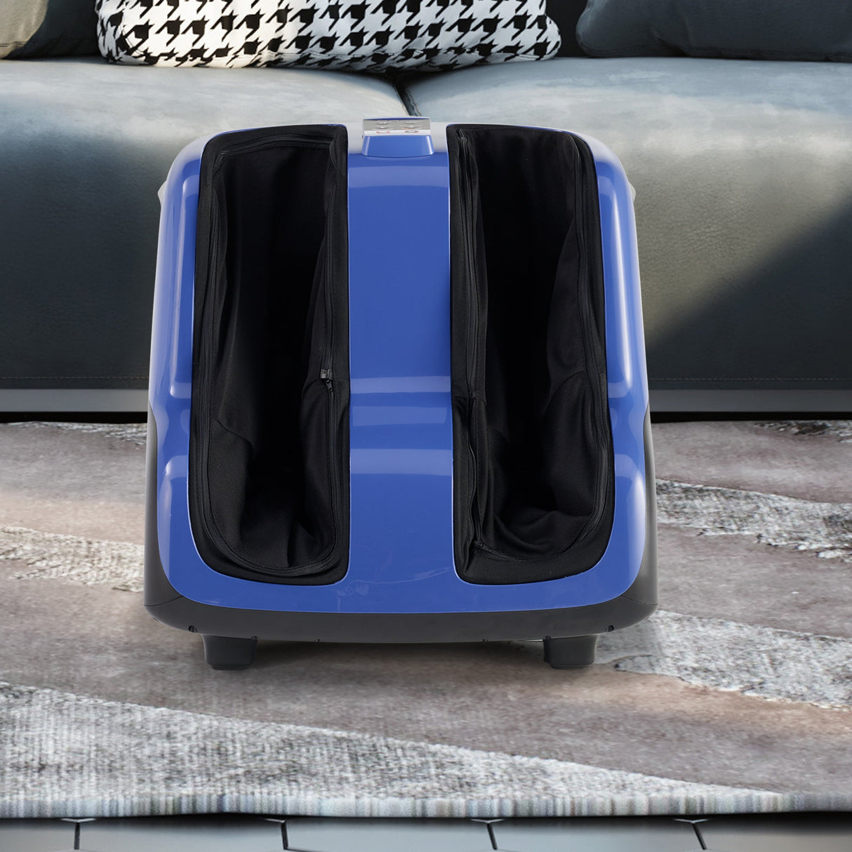Reflex SOL Plus foot and calf massager in blue and black design on gray floor, showing dual massage chambers