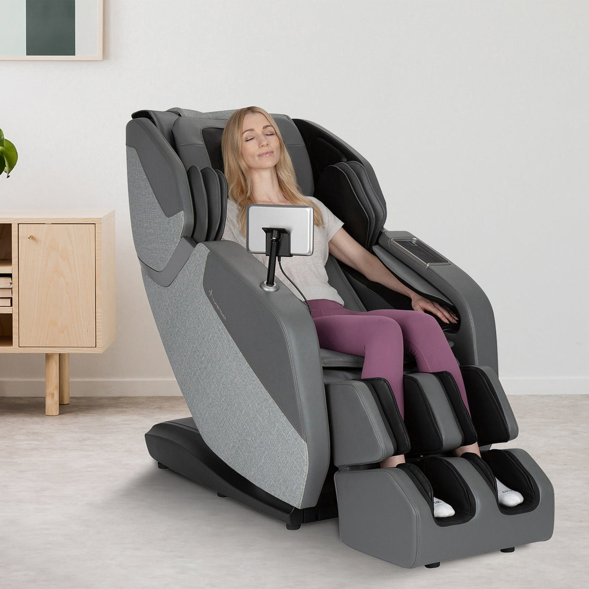 Woman relaxing in the WholeBody® ROVE Massage Chair with L-track and dynamic stretch features.