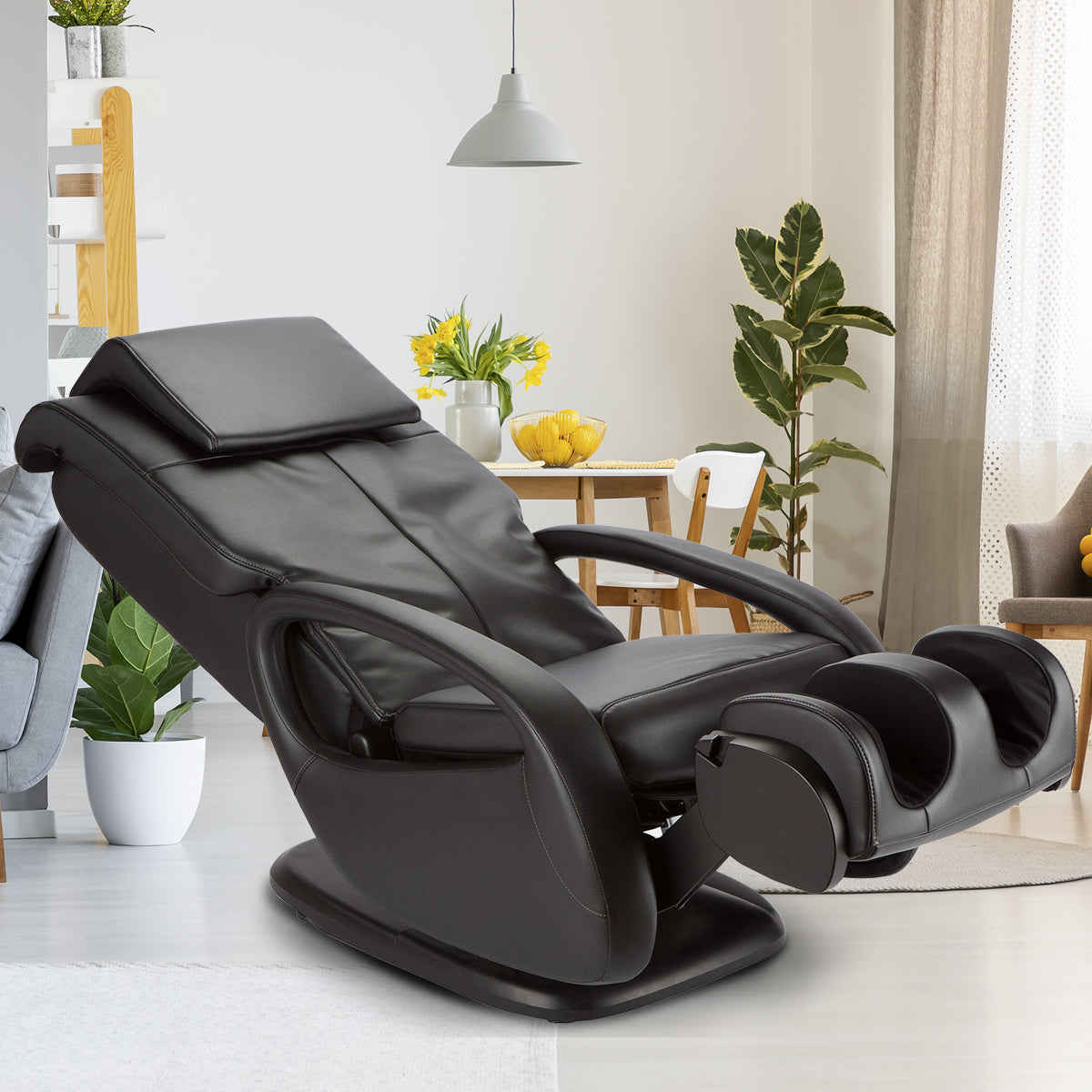 WholeBody 5.1 massage chair in black leather reclined position, shown in modern bright living room with plants