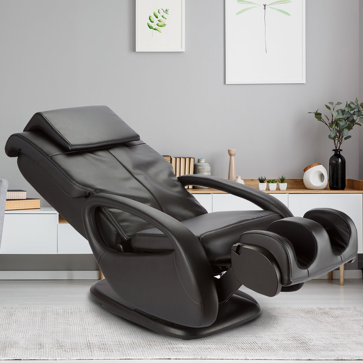 WholeBody 7.1 massage chair in black leather, positioned in modern minimalist room with wall art and decorative plants