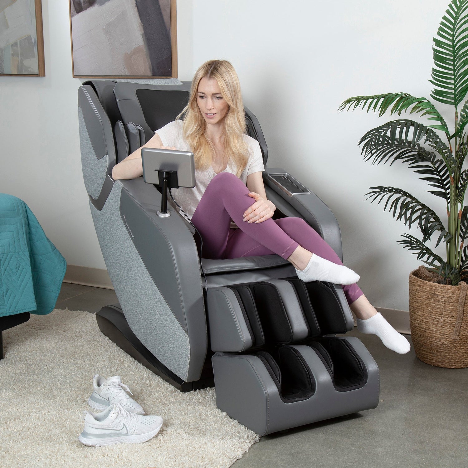 Woman relaxing in the WholeBody® ROVE Massage Chair with extended L-track for full body recovery and stretch.